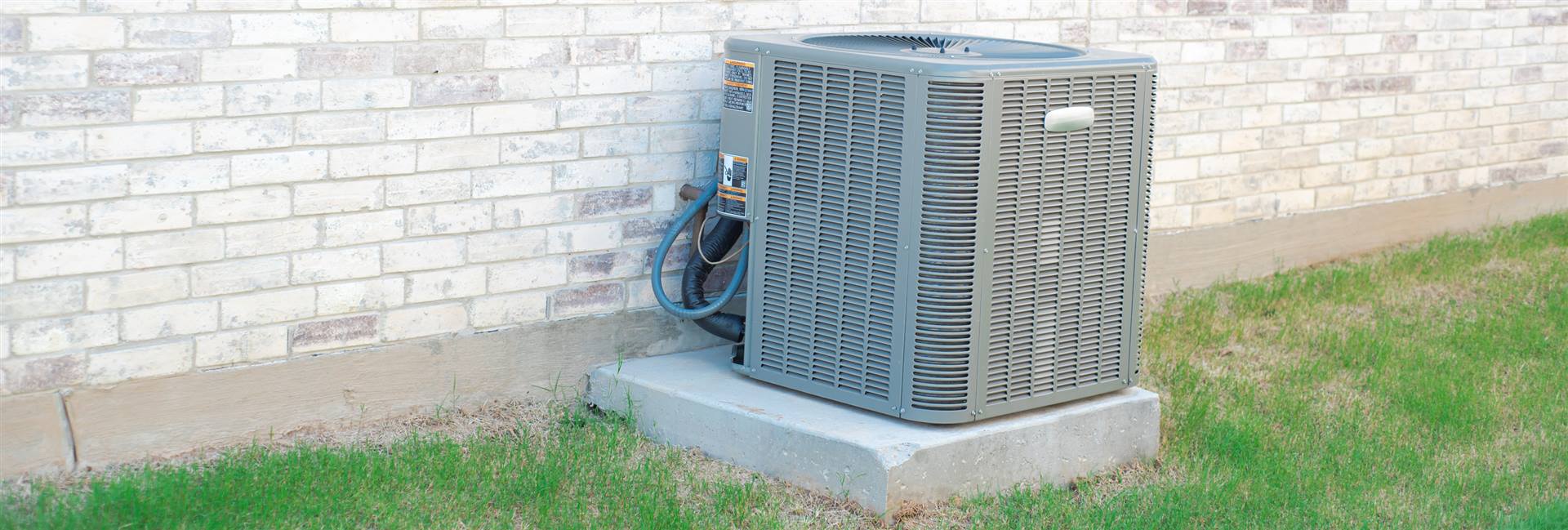 Air-source heat pump outdoor unit installed beside a Great Neck, NY home